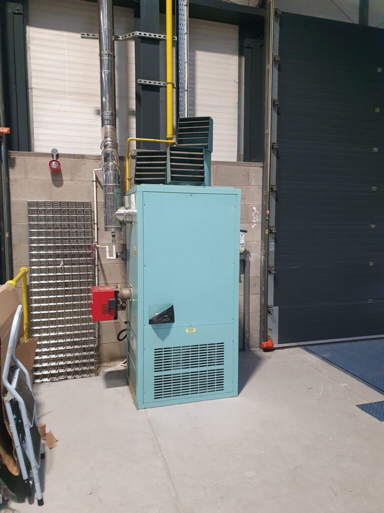 Commercial warm-air heater with flue in industrial unit